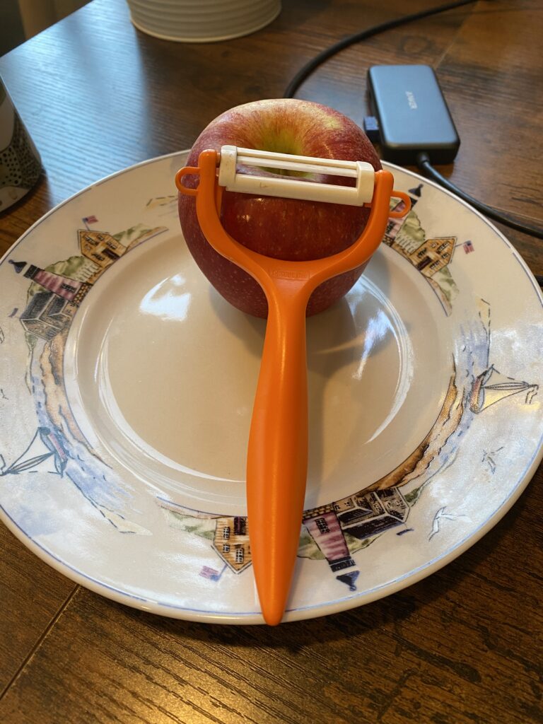 kyocera apple peeler with ceramic blade posing in front of unpeeled apple